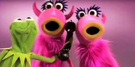Ein Screenshot aus dem Youtube-Video der Muppetshow: zwei pinke Zottelmonster, die singen und Kermit, der ihnen einen Telefonhörer hinhält