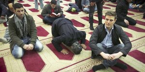 Mehrere Männer auf dem Boden einer Moschee