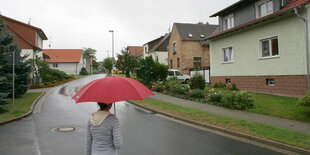 Eine Frau mit Schirm in einem Dorf