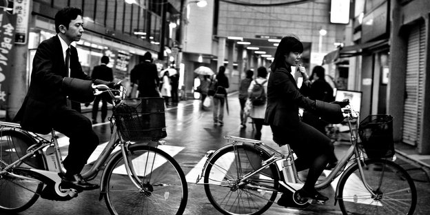 Ein Mann und eine Frau fahren in Business-Kleidung Fahrrad in Tokio Ein Mann und eine Frau fahren in Business-Kleidung Fahrrad in Tokio