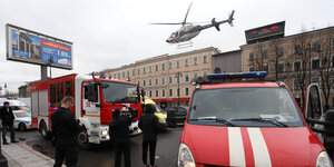 Ein Feuerwehr-Löschzug und mehrere Menschen stehen auf einem Platz