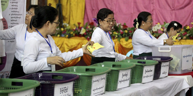 Frauen sortieren Wahlzettel in Wäschekörbe
