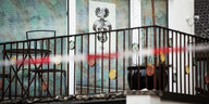 Blick auf den Balkon der Wohnung des mutmaßlichen Todesschützen, an der Wand ein Plakat mit Reichsbürgersymbol, vor dem Balkon Absperrband