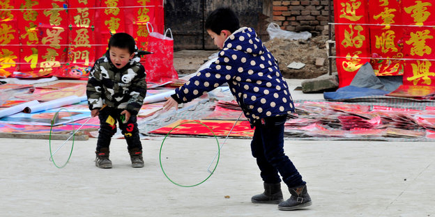 Zwei Kinder spielen mit Reifen