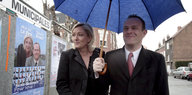 Marine Le Pen und Steeve Briois stehen neben einem ihrer Wahlplakate
