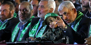 Der neue Chef der Hamas, Jihia al-Sinwar, neben einem kleinen Jungen, vor dem ein Gewehr liegt