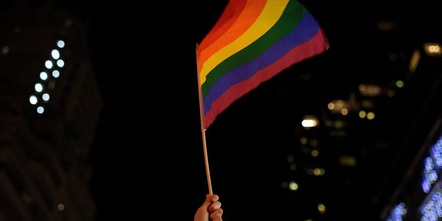 Eine LGBT-Fahne weht vor dunklem Nachthimmel