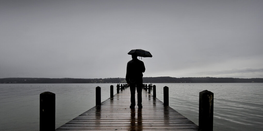 Mann auf Steg, Regen