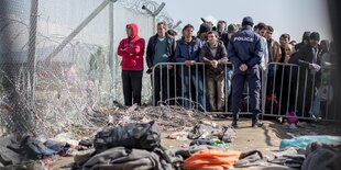 Eine Menschenschlange steht an einem Zaun