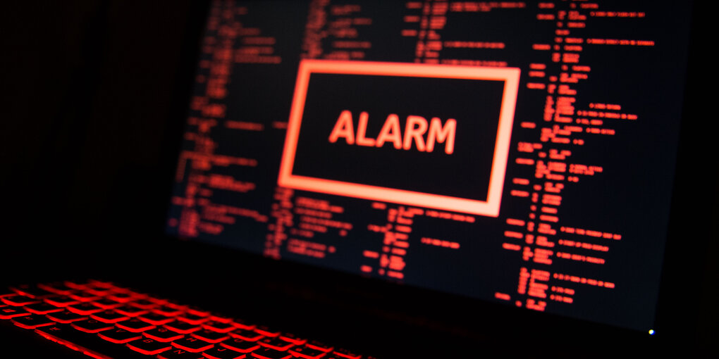 Auf einem Laptop ist in roter Schrift auf schwarzem Hintergrund das Wort „Alarm“ zu sehen