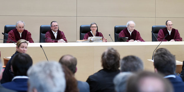 In einem Gerichtssaal sitzen fünf Richter und Publikum