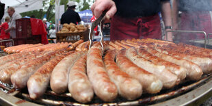 Bratwürste werden auf einem Rost gegrillt