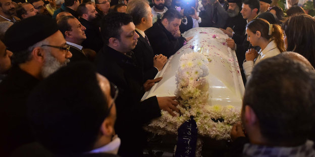 koptische Christen stehen trauernd um einen Sarg
