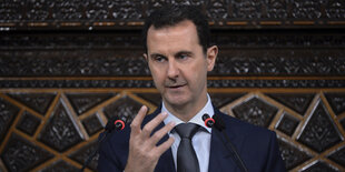 Syriens Diktator Baschar Assad hebt beim Sprechen predigend eine Hand