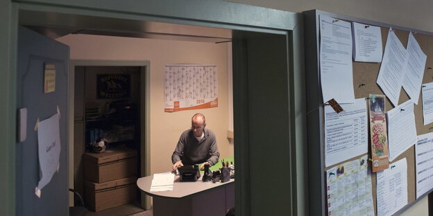 Blick ins Büro von Peter Rausch, der an seinem Tisch sitzt