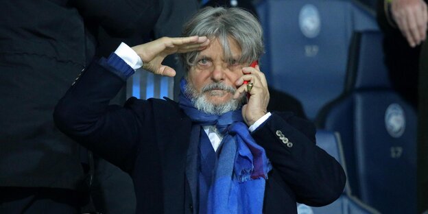 Massimo Ferrero hat die eine Hand zum militärischen Gruß erhoben, mit der anderen hält er sich sein Telefon ans Ohr