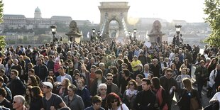 Viele Menschen auf einer Brücke über die Donau in Budapest