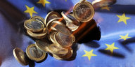 Euromünzen auf einer Europa-Flagge