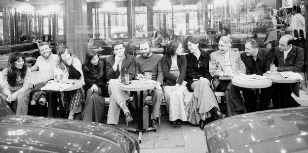Eine Gruppe Menschen sitzt vor einem Café