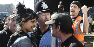 Eine Frau stellt sich einem rechten Demonstranten entgegen, umringt von Polizisten