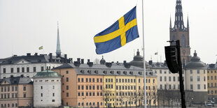 Flagge weht vor Häusern auf Halbmast