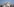 Eine graue Rauchwolke steigt über dem hellblauen Himmel über Diyarbakir auf