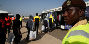 In einer Schlange warten Menschen am Airport in Banjul, Gambia
