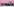 16 Musiker mit Blasinstrumenten und Schlagzeugen vor einer rosa Wand.