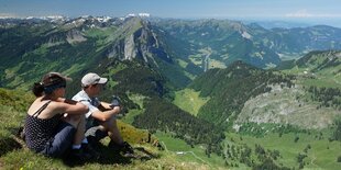 Zwei Menschen schauen über sommerliches Bergland