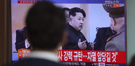Aufnahmen von Kim Jong Un in einem Fernsehgerät, davor ein unscharfer Kopf