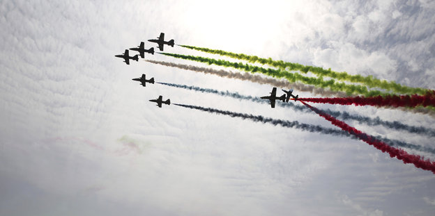 Flugzeuge im Formationsflug mit farbigen Kondensstreifen