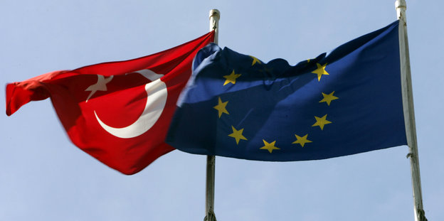 Die türkische Fahne und die der EU wehen vor blauem Himmel