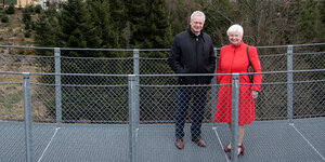 Eine Frau und ein Mann auf einer Brücke - im Hintergrund Büume und Wiese