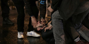 Ein Protestler wird zu Boden gedrückt