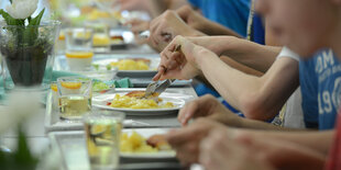 Kinder an einem langen Tisch essen zu Mittag