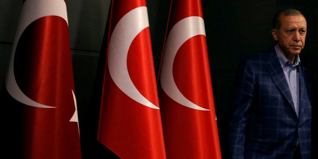 Erdogan neben drei Türkei-Flaggen