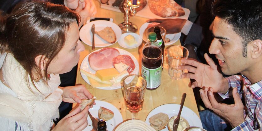 Menschen unterhalten sich an gedecktem Tisch