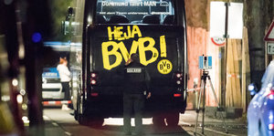 Polizisten stehen in der Nacht vor dem attackierten BVB-Bus, auf dem gelb auf schwarz Heja BVB steht