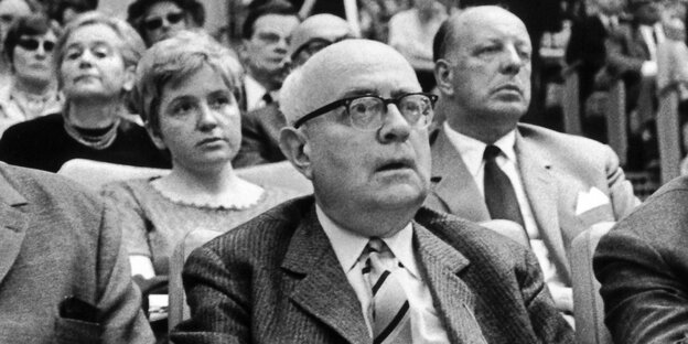Theodor W. Adorno sitzt in einem Zuschauersaal und guckt überrascht Theodor W. Adorno sitzt in einem Zuschauersaal und guckt überrascht