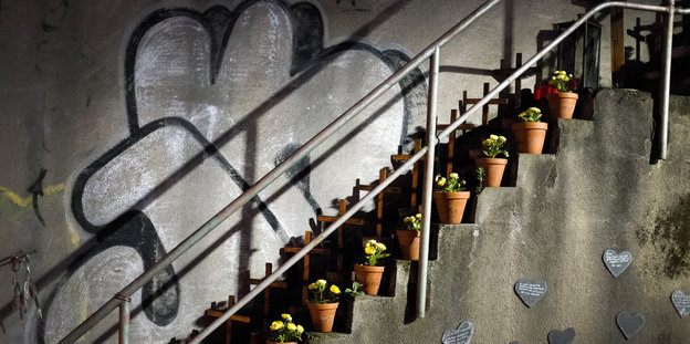 Kreuze und Blumen sind entlang eines Treppengitters angebracht