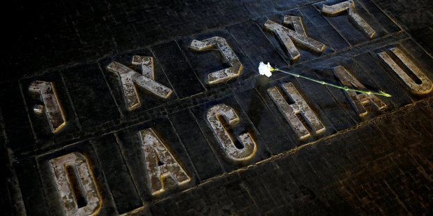 Dachau steht in hebräischen und lateinischen Buchstaben auf schwarzem Grund