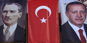 Drei Banner hängen nebeneinander, auf einem ist der türkische Staatsgründer Atatürk zu sehen, auf einem Erdogan, in der Mitte die türkische Flagge