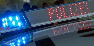 Polizei steht in roten Buchstaben neben einem Blaulicht