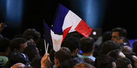 über einer Menschenmenge flattert eine französische Flagge
