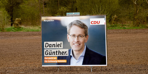 Ein Wahlkampfplakat auf einem Acker