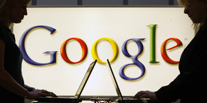 Zwei Laptops vor einem Google Logo