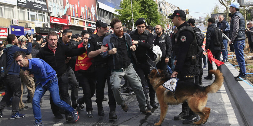 Polizisten führen einen Demonstranten ab.