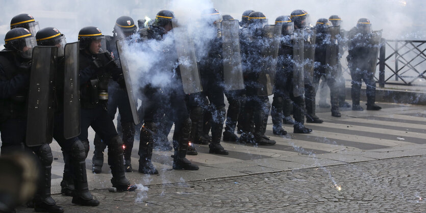 Polizisten schützen sich mit Schildern