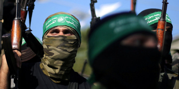 Kämpfer der Hamas halten Waffen hoch