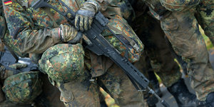 ein Soldat in Tarnkleidung mit Gewehr, Helm und Uniform